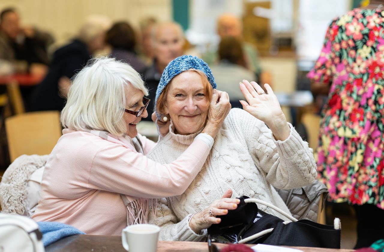 Two older women sharing a warm moment at a community gathering
